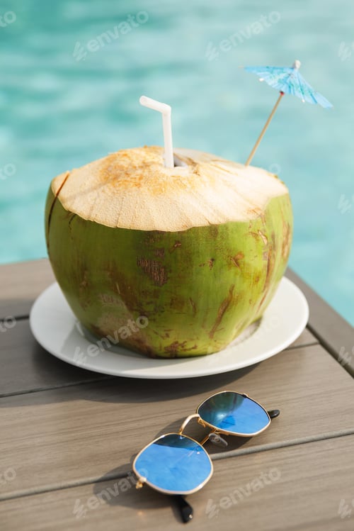 Preview: Fresh coconut drink and sunglasses on the table