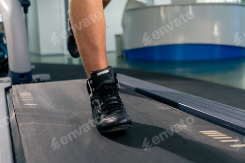 Preview: close-up of the legs of an athlete running on a treadmill in a gym during cardio training
