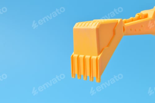 Preview: Plastic digger toy isolated on a blue background