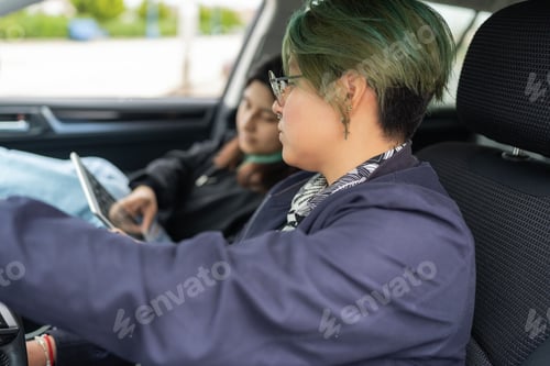 Preview: Lesbian couple using a digital tablet inside a car