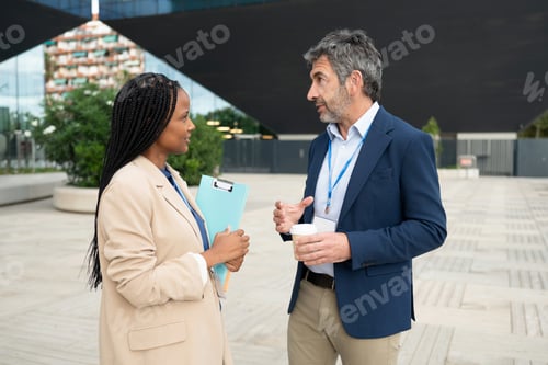 Preview: Diverse business colleagues talking during city coffee break