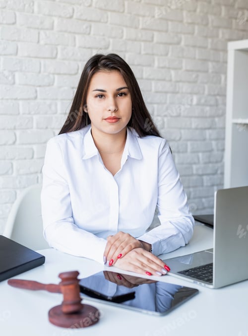 Female Professional with Gavel Sitting at Desk