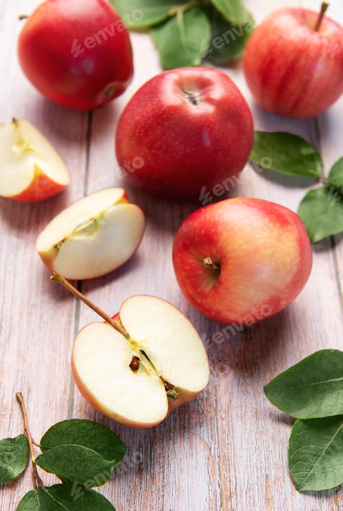 Preview: Red apples and slices on light wood background