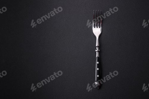 Preview: Metal kitchen fork on a dark textured concrete background