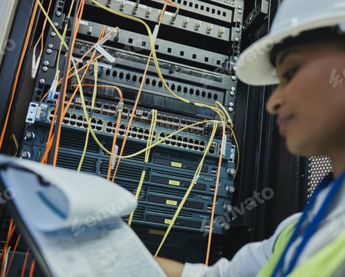 Preview: Mama would be proud. Shot of a young woman working on cables in a server room.