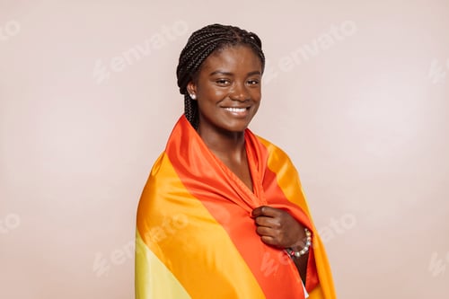 Preview: Happy woman with braids holding rainbow flag
