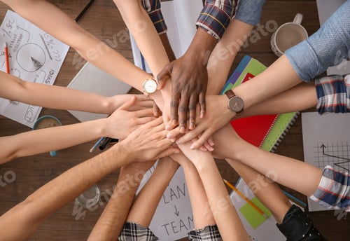 Preview: People putting hands together at table, top view. Unity concept