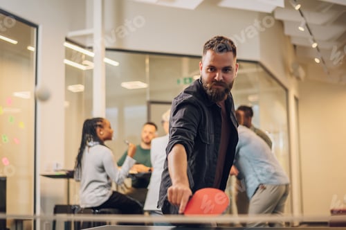 Preview: Young people playing table tennis in the office at work