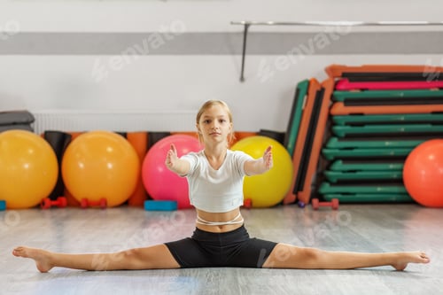Preview: Young girl in split pose reaching forward