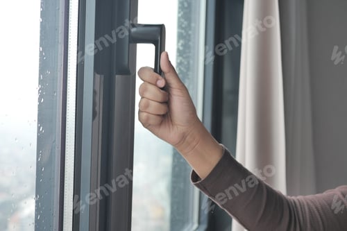 Preview: Young woman opening window in flat