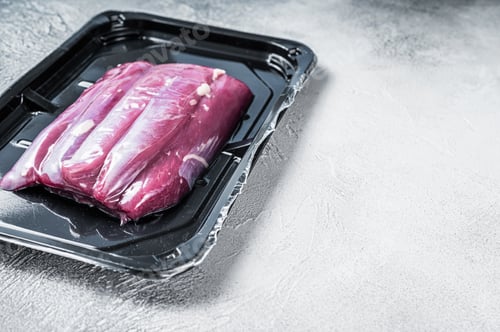 Preview: Raw lamb tenderloin in vacuum packaging. White background. Top view. Copy space