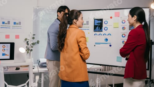 Preview: Business team analyzing financial charts and graphs on whiteboard during a productive meeting in mod
