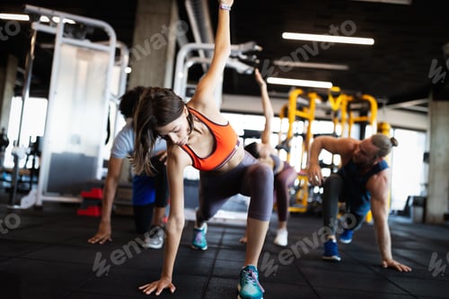 Preview: Healthy young people doing exercises at fitness studio
