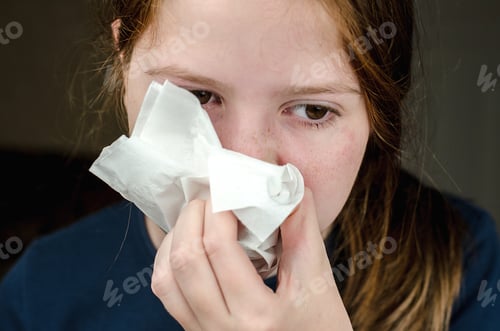 Preview: Portrait of a teenage girl who fell ill and blows her nose into a napkin