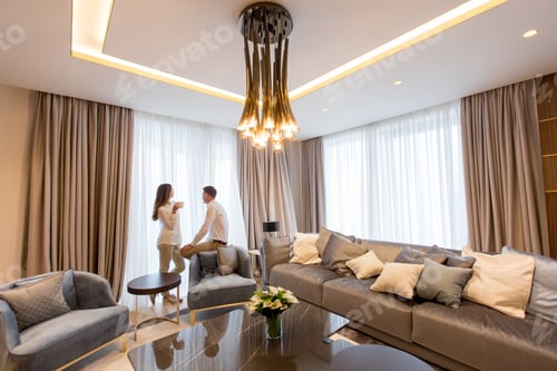 Preview: Young couple relaxing and talking with coffee cups in the luxurious room