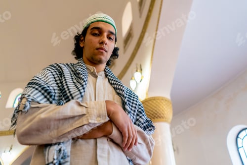 Preview: Muslim man's face standing on carpet in middle of a prayer hall at a mosque with his head raised up