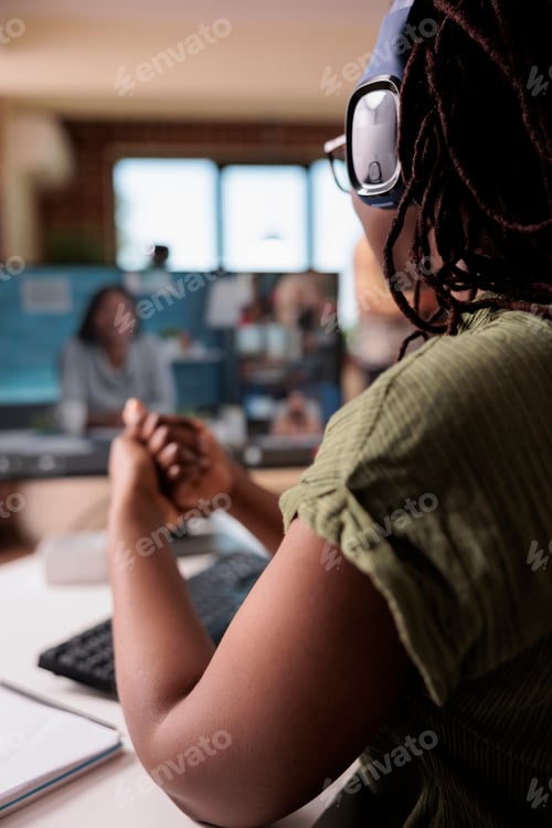 Preview: Closeup on wireless headphones on african american woman in video call with startup owner