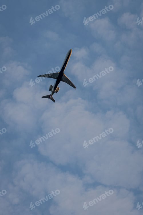 Preview: Low angle shot of an Airplanes flying overhead in the blue cloudy sky in dylight