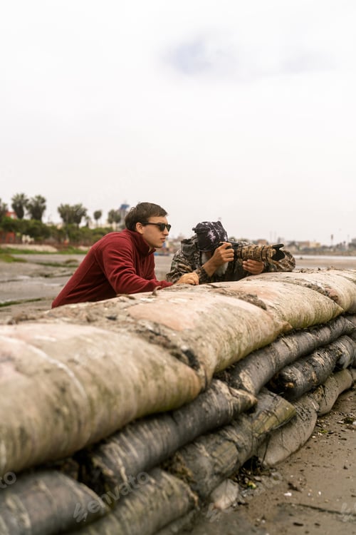 Preview: Two men watching birds and photographing in wetland
