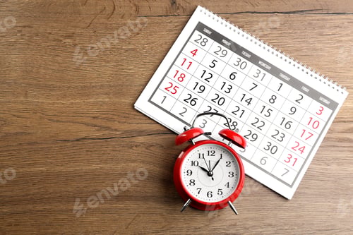 Preview: Calendar and alarm clock on wooden table, flat lay. Space for text