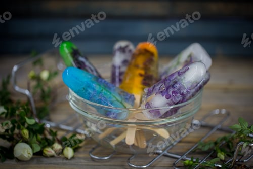 Preview: fresh colored ice cream on wooden background, frozen flowers