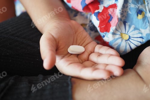 Preview: close up of medical pills on palm of child hand