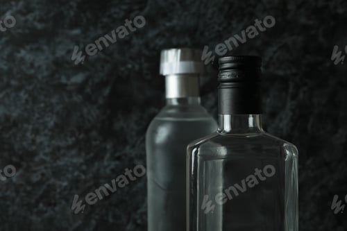 Preview: Blank bottles of vodka on black smokey background, space for text