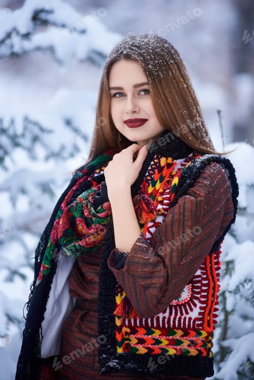 Preview: Portrait of young woman in long woolen stylish dress and dark kerchief with bright floral pattern.