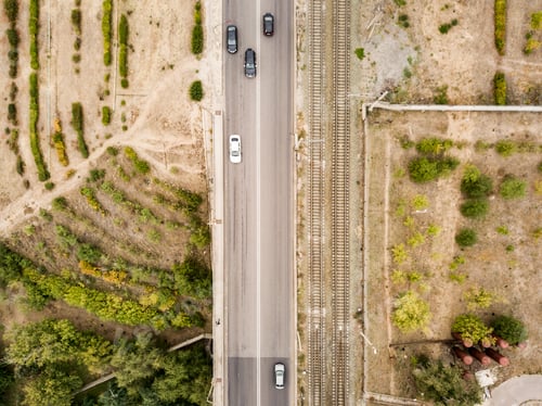 Preview: aerial top view of countryside isolated road with railway tracks f