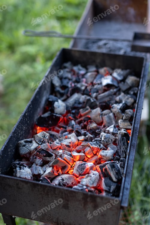 Preview: Barbecue grill with glowing and flaming hot charcoal briquettes