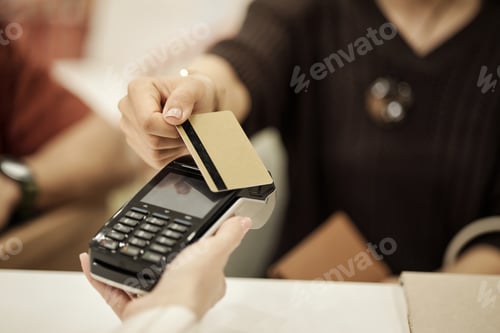 Preview: Caucasian Young Adult Woman Making Payment Using Credit Card at Checkout Counter