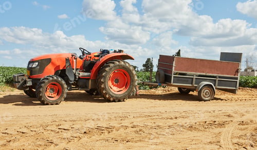 Preview: Tractor with trailer for harvesting at the farm on sunny spring day