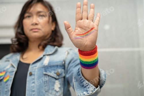 Preview: Asian lady wearing rainbow flag wristbands, symbol of LGBT pride month celebrate annual in June s