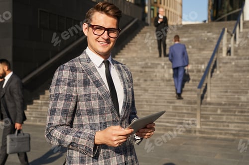 Confident Man in Plaid Suit With Tablet