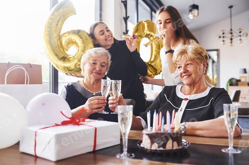 Preview: Balloons with number 60. Senior woman with family and friends celebrating a birthday indoors