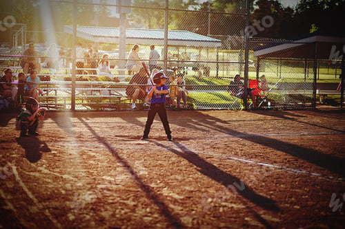Preview: Boy playing baseball up to bat going to hit the ball on a summer evening