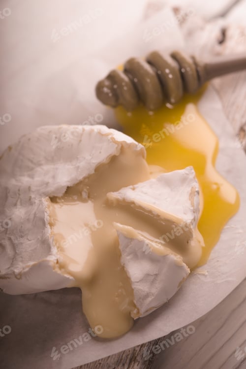Preview: Brie cheese, slices, honey on parchment partial blur