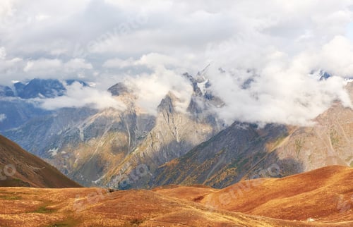 Preview: Fantastic snow-capped mountains in the beautiful cumulus clouds. Main Caucasian Ridge. Type Mount