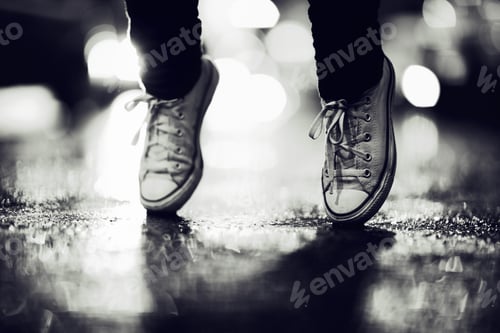 Preview: Cropped image of a person wearing sneakers standing on their toes in the street