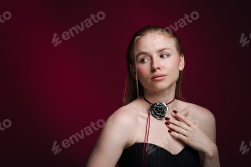 Preview: Beautiful woman in stylish necklace posing on dark red background. Space for text