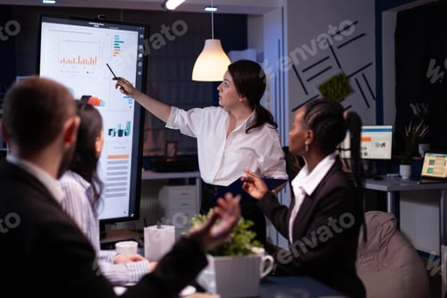 Preview: Multi ethnic businesspeople brainstorming company ideas checking graphs statistics