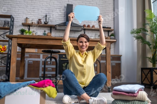 Preview: Joyous Caucasian female volunteer calling for clothing donation