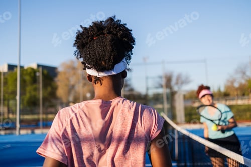 Preview: Two female tennis players preparing to play a match on a sunny day