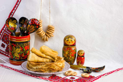 Preview: Background with pancakes, wooden utensils with Khokhloma painting, matryoshka, rushnik, sushki for M