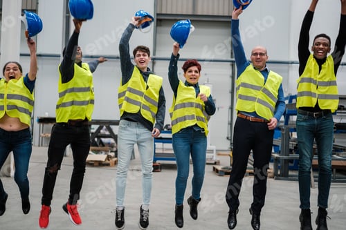 Preview: Coworkers from an industrial factory jumping together happily