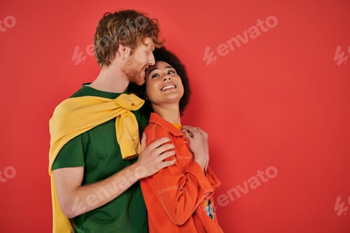 Preview: interracial couple hugging and smiling on coral background, cultural diversity, vibrant colors,