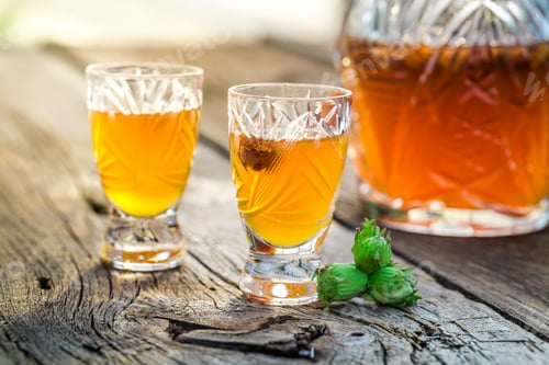 Preview: Homemade liqueur with alcohol and hazelnuts on old wooden table