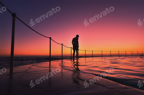 Preview: A lone swimmer stands at the edge of the pool at sunset