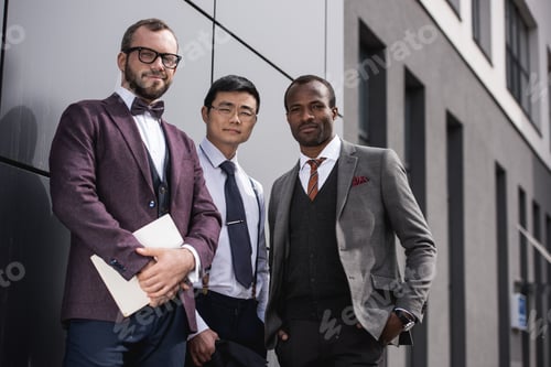 Preview: young stylish multiethnic businessmen in formalwear posing outdoors, business team meeting