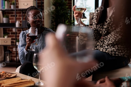 Preview: Diverse group of close friends sitting in living room while enjoying fun time together